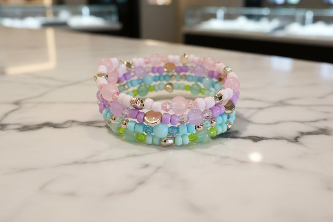 Embrace the beauty of the pastel tones with our 4 coil memory wire bracelet. With beads in shades of pink, purple, blue, and green, accented by rose gold spacer beads, this bracelet is a must-have for any jewelry lover. Feel confident and stylish with this unique and versatile accessory!