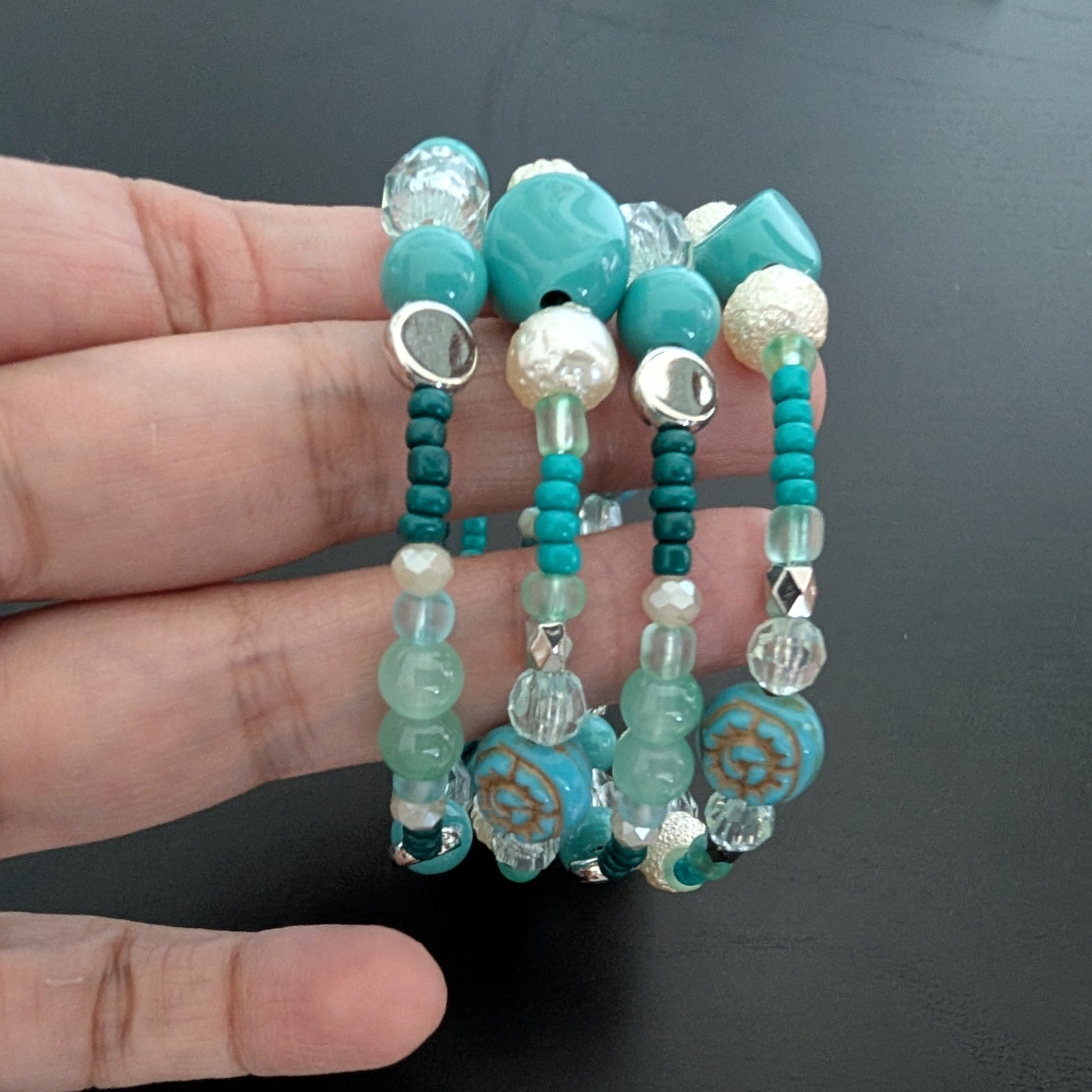 Elevate your style with this stunning 4-coil memory wire bracelet featuring a harmonious blend of turquoise, white, and crystal beads. Its flexible design ensures a comfortable fit for any wrist, while the sparkling crystals add a touch of elegance to any outfit. Perfect for layering or wearing alone, this bracelet effortlessly combines durability with eye-catching beauty.