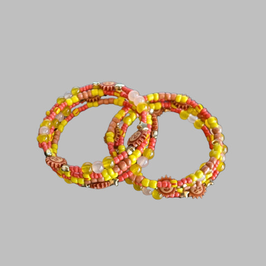 This vibrant memory wire bracelet features four coils adorned with yellow and sun beads, complemented by yellow, tan, and orange spacer beads. Its flexible design ensures a comfortable fit for any wrist size, making it an eye-catching accessory that brightens your look with warm, sunny hues. Perfect for adding a splash of color and effortless style to your everyday outfits.