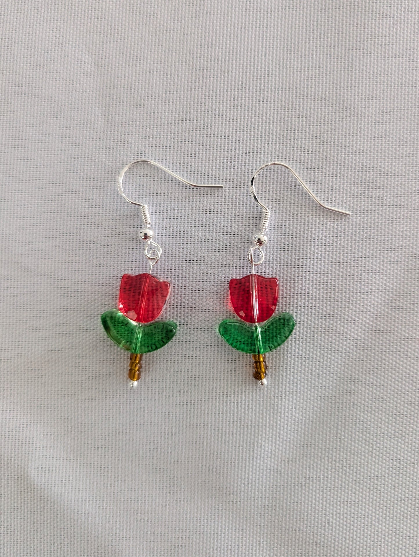 Delicate crystal and seed beads form an enchanting tulip design, suspended from hypoallergenic 925 sterling silver hooks. These lightweight earrings measure just 1.5 inches, making them perfect for everyday elegance or layering with other pieces. At only 0.1 oz, they're comfortable enough to wear all day without fatigue. The shimmering bead work catches light beautifully, adding a touch of sparkle and sophistication to any outfit. Ideal for those who appreciate handcrafted jewelry with timeless appeal.