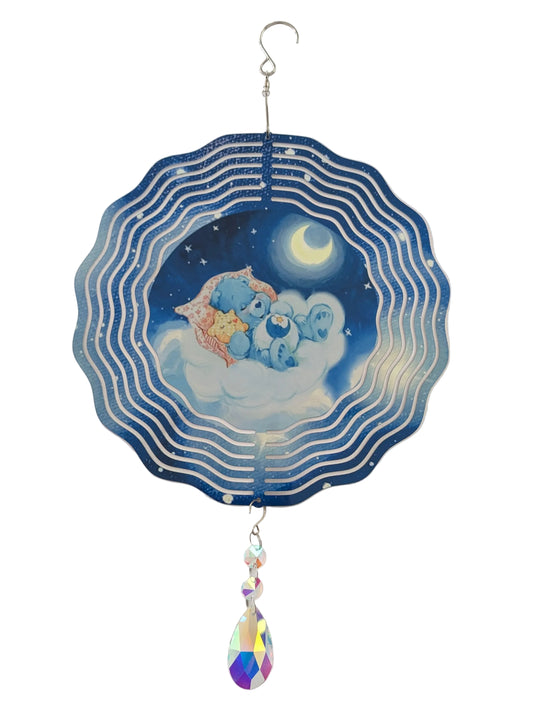Bring whimsical charm to your outdoor space with this delightful 10-inch wind spinner showcasing Bedtime Care Bear on both sides. As it spins gracefully, stunning 4-inch teardrop crystal prisms dance with light, casting rainbow sparkles across your garden. Crafted from lightweight yet robust aluminum with a protective powder-coated finish, this spinner laughs in the face of rust and corrosion. The UV-treated image stays vibrant and cheerful through countless sunny days. Safe, smooth edges and hassle-free se