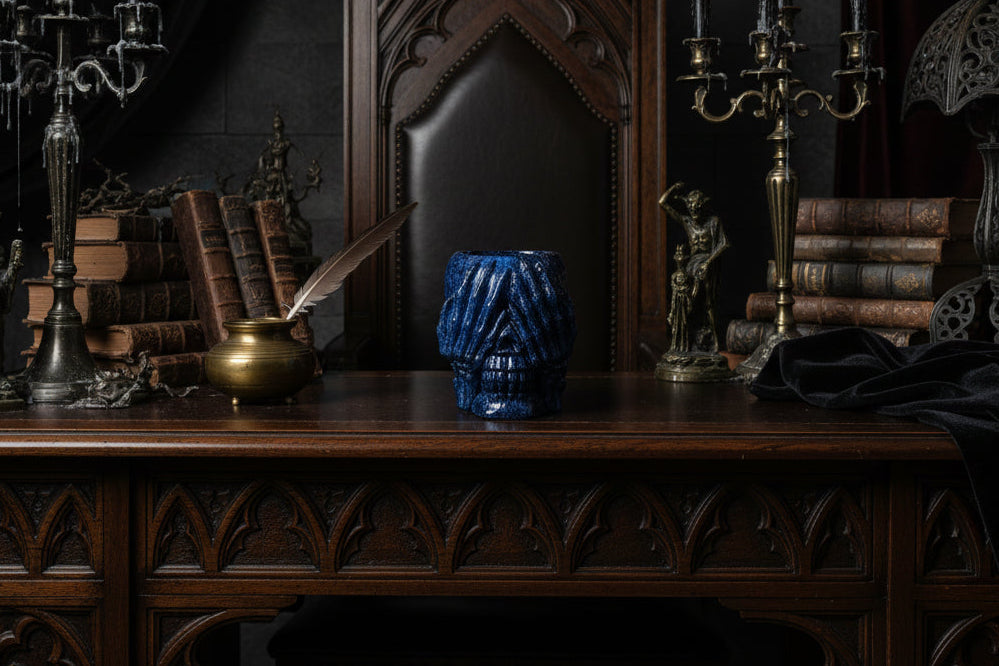 Blue see no Evil Skull Trinket holder on a dark wooden desk with gothic decor
