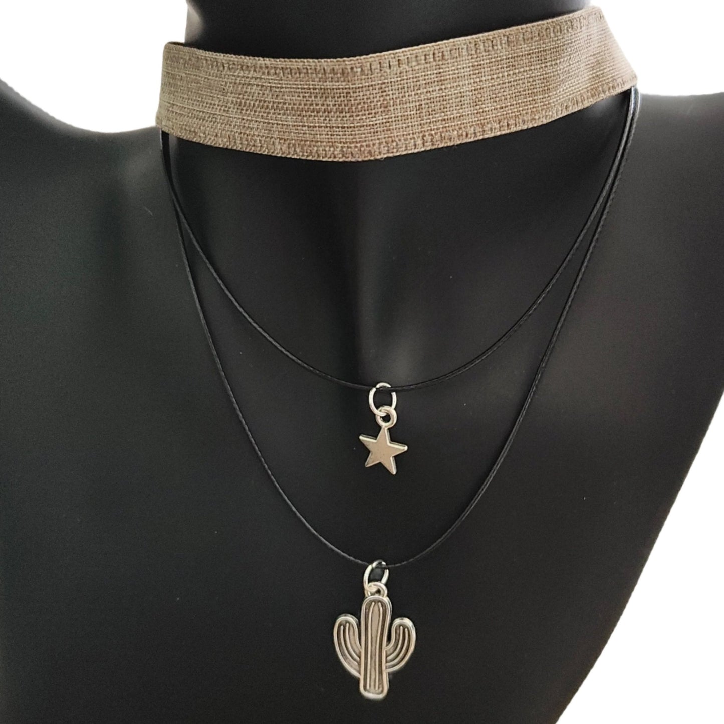 Elevate your style with this trendy and unique choker necklace. The brown ribbon adds a touch of warmth while the silver star and cactus charms add a playful and chic touch. Made with two polyester strands for durability and comfort. A must-have addition to your jewelry collection.