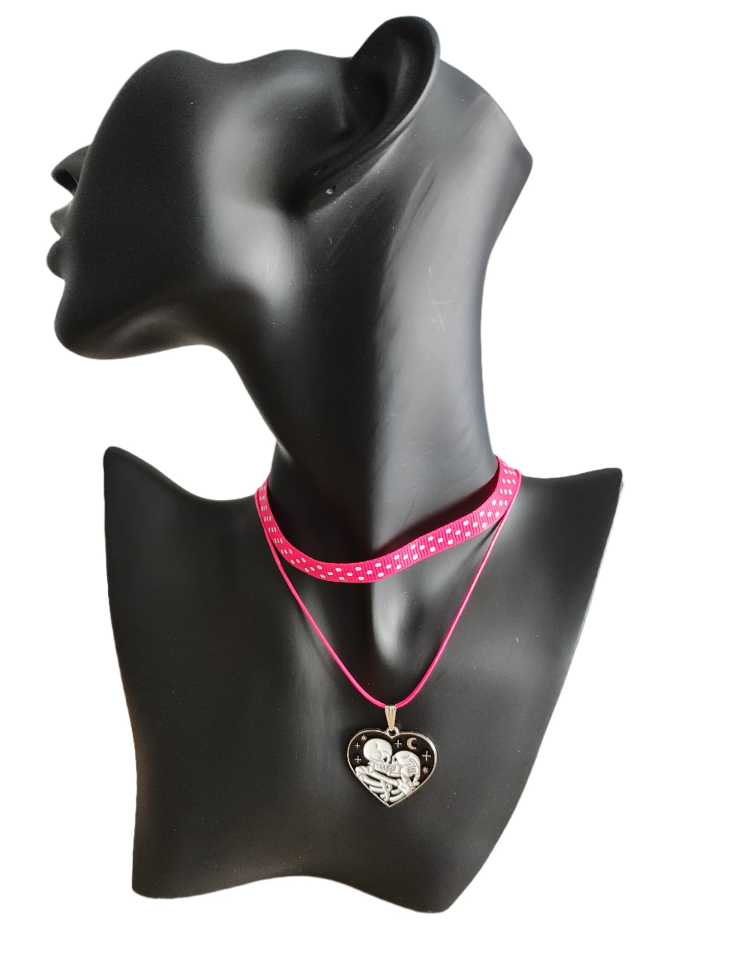 Add a touch of edgy sophistication to any look with our Choker Necklace. Made of polka dot fabric ribbon, this necklace features one durable polyester strand and a black skeleton heart charm. Perfect for those looking to make a statement.