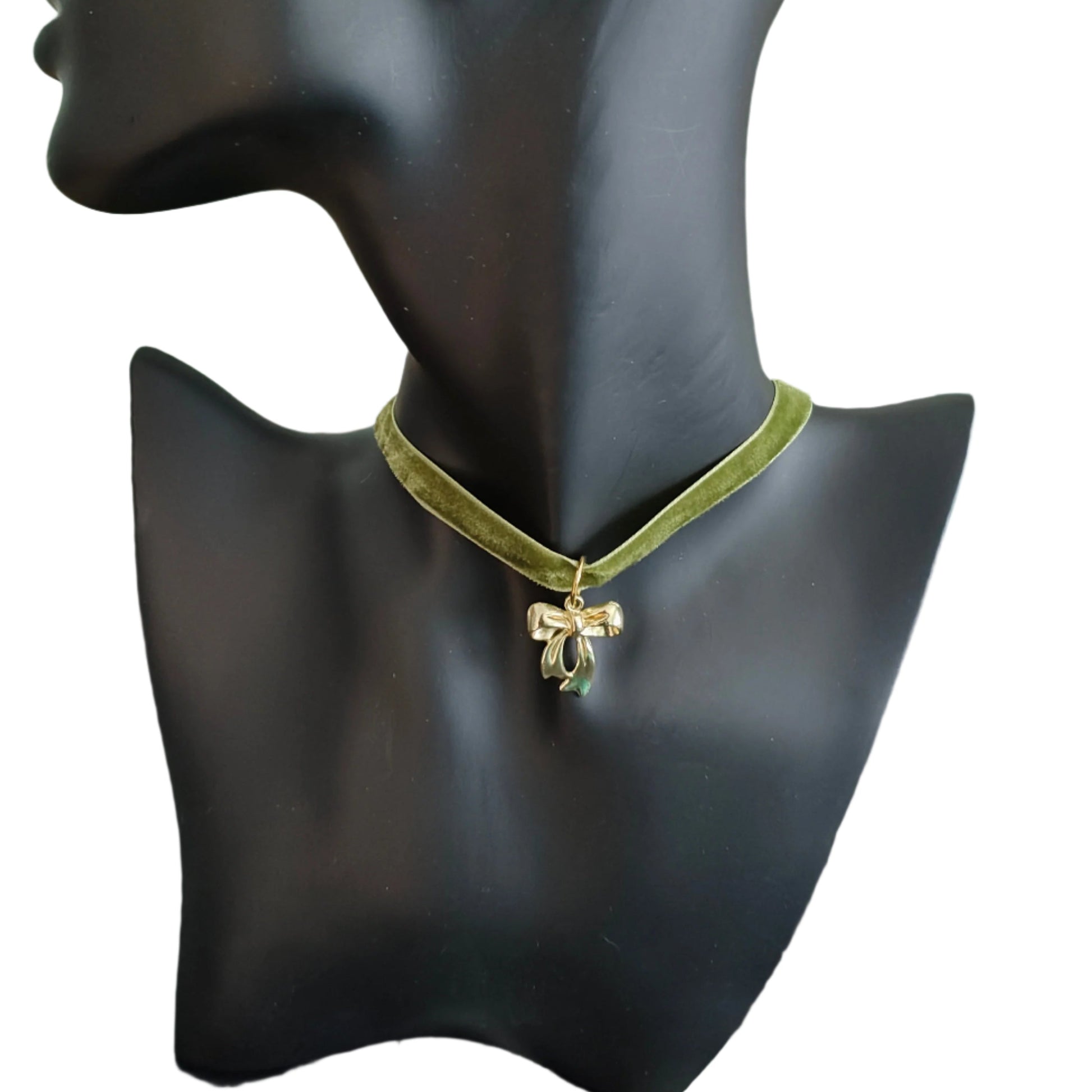 This stunning necklace features an olive green velvet ribbon that elegantly wraps around your neck, accented by a delicate gold bow charm. The soft texture of the ribbon and the eye-catching charm create a beautiful and sophisticated look. Perfect for adding a touch of class to any outfit!
