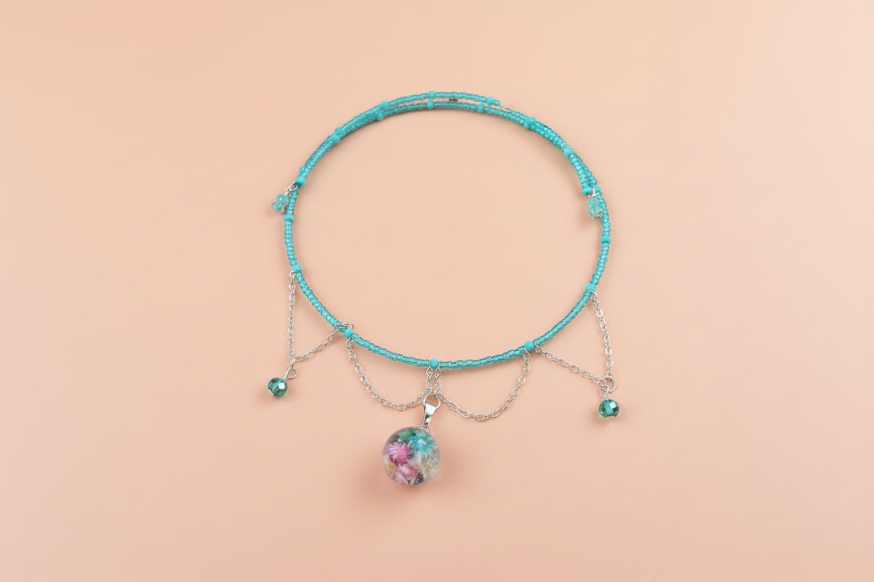 Turquoise beaded necklace with a floral bead pendant on a beige background