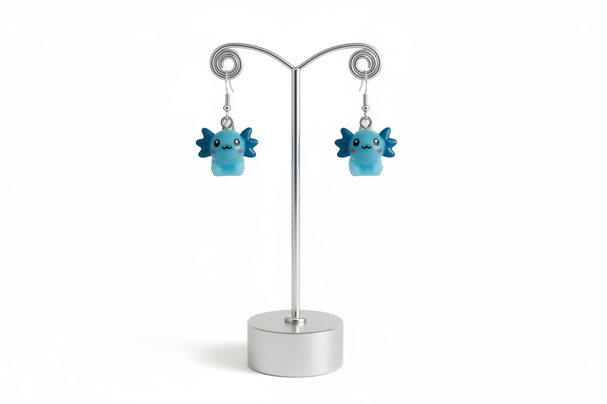 Blue axolotl character earrings on a silver stand against a white background