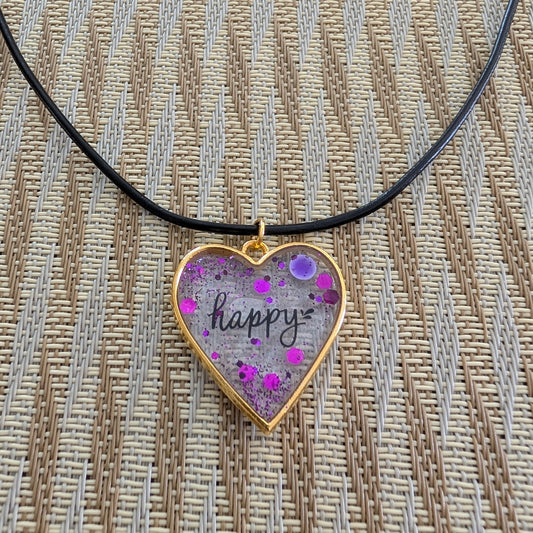 Fall in love with this 18 inch resin and glitter gold heart pendant necklace! The vibrant charm hangs beautifully on a black 2mm leather cord, adding a touch of happiness to any outfit. With a weight of only 0.2 oz, you'll hardly feel it's there. Don't miss out on this unique and stylish piece!