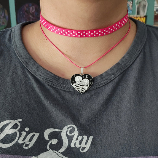 Add a touch of edgy sophistication to any look with our Choker Necklace. Made of polka dot fabric ribbon, this necklace features one durable polyester strand and a black skeleton heart charm. Perfect for those looking to make a statement.