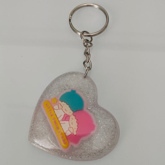 This 3D resin Kiki & Lala heart keychain is a must-have accessory for any fan of the beloved characters. The intricate design and vibrant colors are sure to catch the eyes and hearts of all who see it. Carry your keys with style and show off your love for Kiki & Lala with this charming keychain!