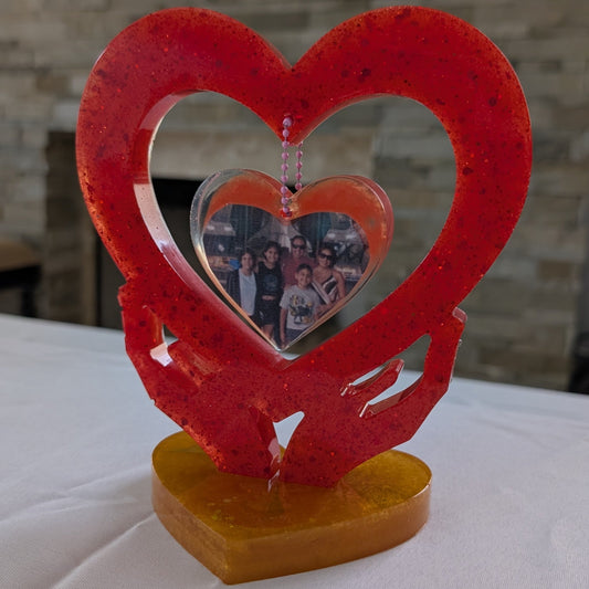 Transform your favorite photo into a one-of-a-kind keepsake with this custom epoxy resin knickknack. Hand-crafted to showcase your image nestled between two hands forming a heart, this charming piece features a smooth, glass-like finish that's built to last.