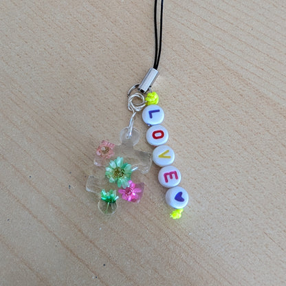 Spice up your phone with this charming resin charm, adorned with real dried flowers and beads. The 3.75 inch length adds a touch of flair to any device. (It's like a bouquet, but for your phone!)

Phone charm - Resin charm with dried flowers and beads