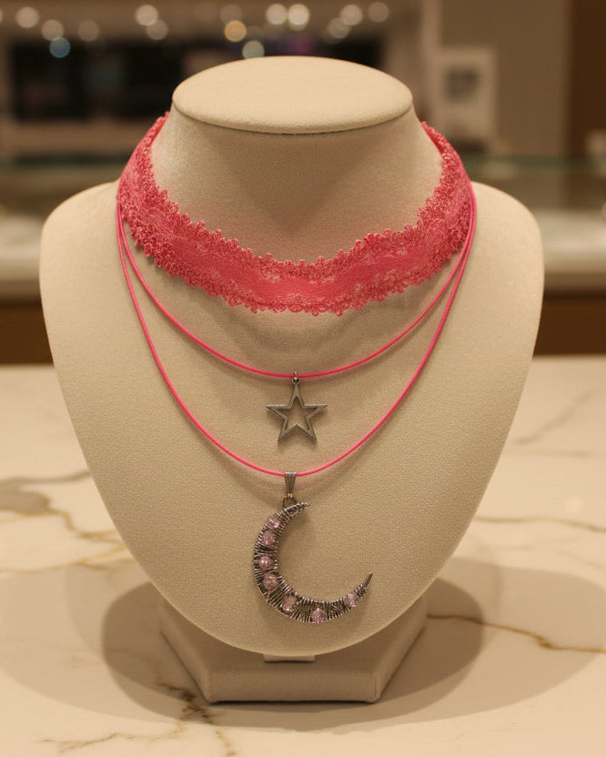 Transform any outfit into a stellar ensemble with this playful Necklace-Choker! Featuring an elastic lace ribbon, two polyester strands, and a crystal-studded silver moon and star charm, this necklace adds a touch of whimsy to your look. Plus, with a 2 inch extension chain, it's perfect for any neckline.