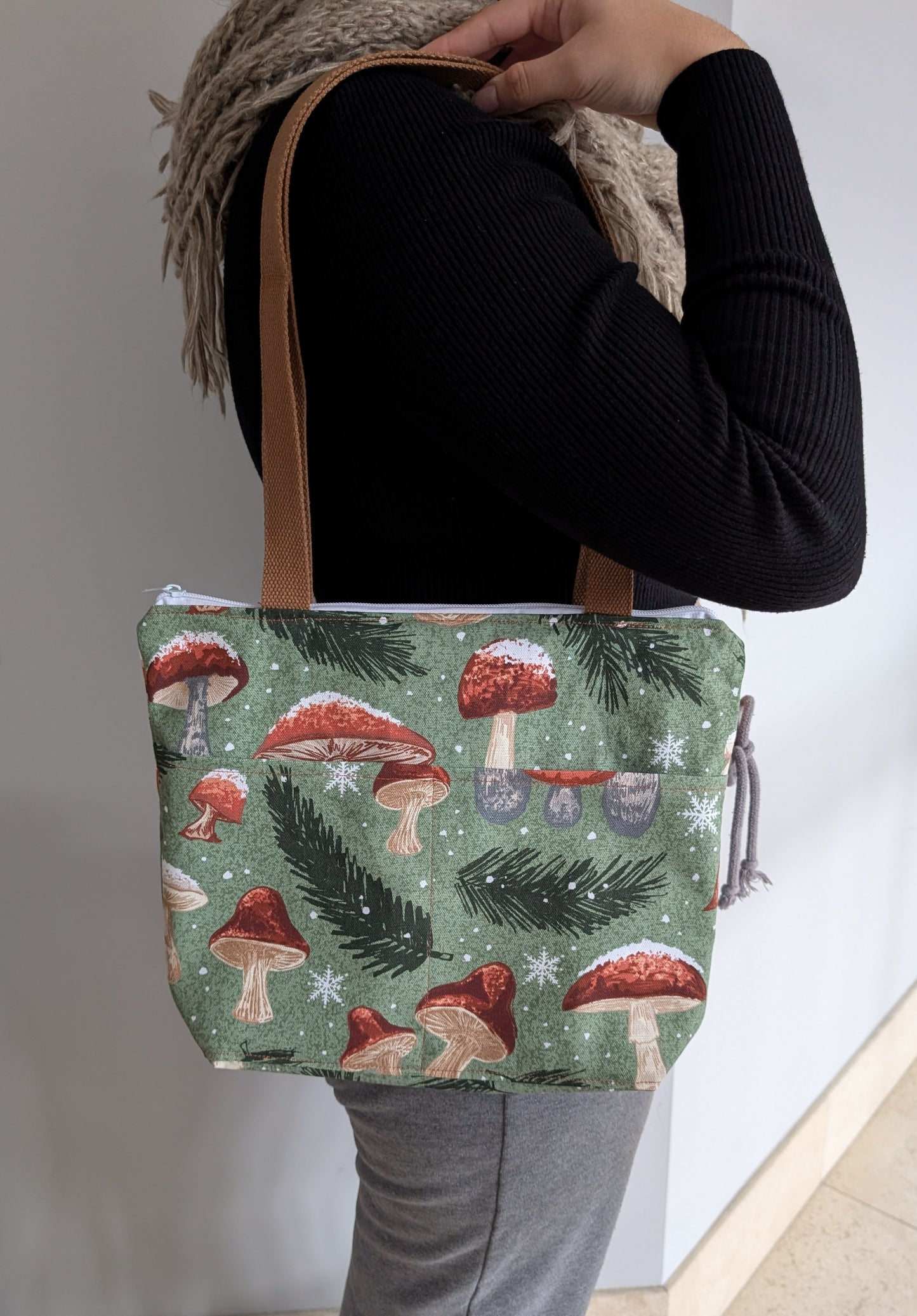 Crafted from durable cotton, this 13x9" bag features a sturdy 3.5" flat bottom and comfortable 26-inch straps for easy carrying. The vibrant orange lining adds a pop of color inside, while two outer pockets and one inner pocket keep your essentials organized. 