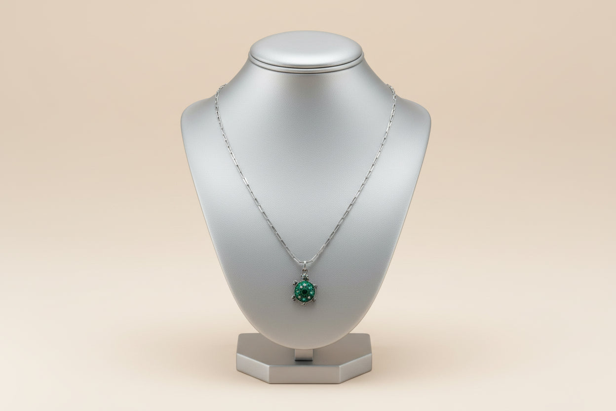 Necklace with a green turtle pendant on a beige background