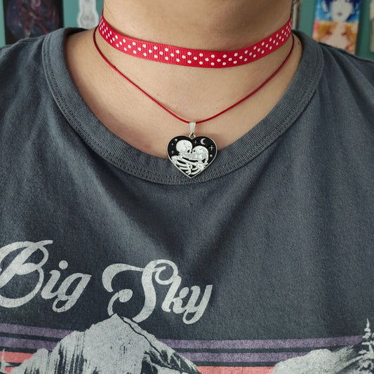 Add a touch of edgy sophistication to any look with our Choker Necklace. Made of polka dot fabric ribbon, this necklace features one durable polyester strand and a black skeleton heart charm. Perfect for those looking to make a statement.