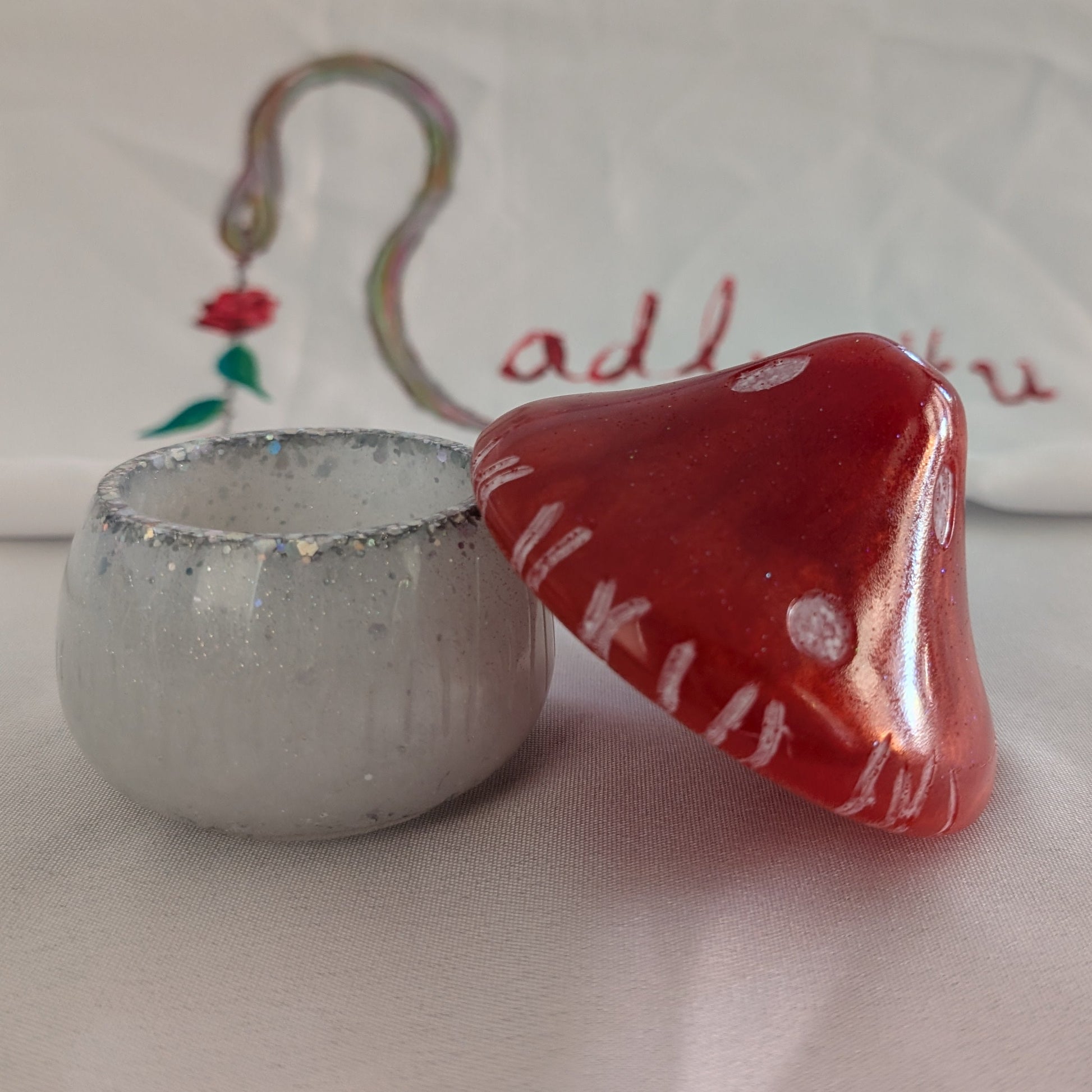 This charming hand-crafted resin mushroom trinket brings whimsical elegance to any space. Meticulously sculpted from epoxy resin, it features a smooth, glass-like finish that's both durable and non-porous—perfect for storing small treasures, jewelry, or keepsakes. The removable lid makes access effortless, while its compact 4.5-inch height and 4x4-inch width fit seamlessly on shelves, desks, or nightstands. At just 12.4 ounces, it's lightweight yet substantial enough to feel premium. Each piece showcases th