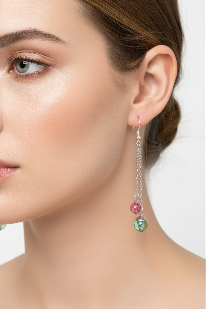 Close-up of a woman wearing earrings with colorful beads on a neutral background