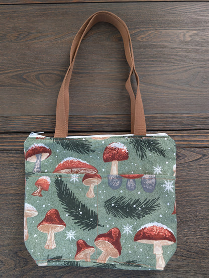 Snowy Mushrooms bag with orange lining two outer pockets one inner pocket and a zipper closure