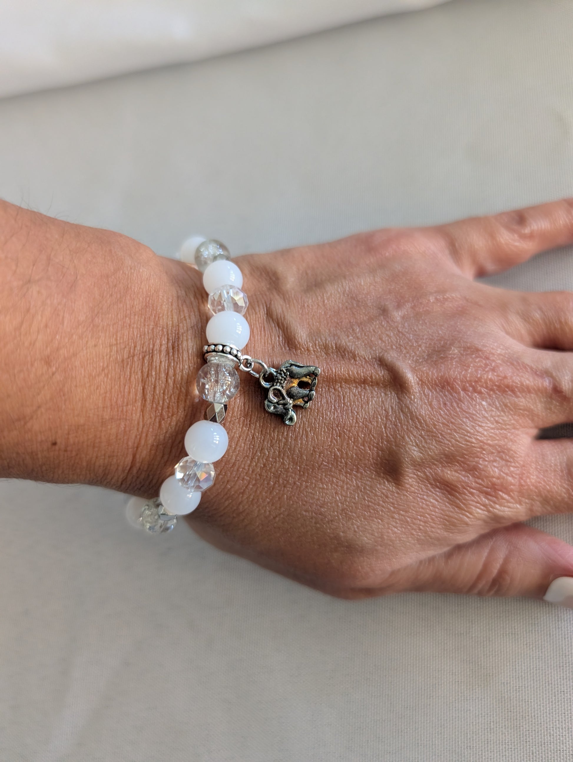 Celebrate wisdom and grace with this luminous elastic bracelet featuring a charming silver elephant charm. Strung with 8mm white and clear beads that sparkle with crystal and glass accents, complemented by delicate silver spacers, this piece radiates understated elegance. The elastic design stretches to fit comfortably on any wrist—no clasps needed—making it perfect for everyday wear or stacking with your favorite bracelets. At just 0.50 oz, it's lightweight enough to wear all day without fatigue. Whether y