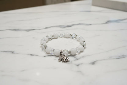 Celebrate wisdom and grace with this luminous elastic bracelet featuring a charming silver elephant charm. Strung with 8mm white and clear beads that sparkle with crystal and glass accents, complemented by delicate silver spacers, this piece radiates understated elegance. The elastic design stretches to fit comfortably on any wrist—no clasps needed—making it perfect for everyday wear or stacking with your favorite bracelets. At just 0.50 oz, it's lightweight enough to wear all day without fatigue. Whether y