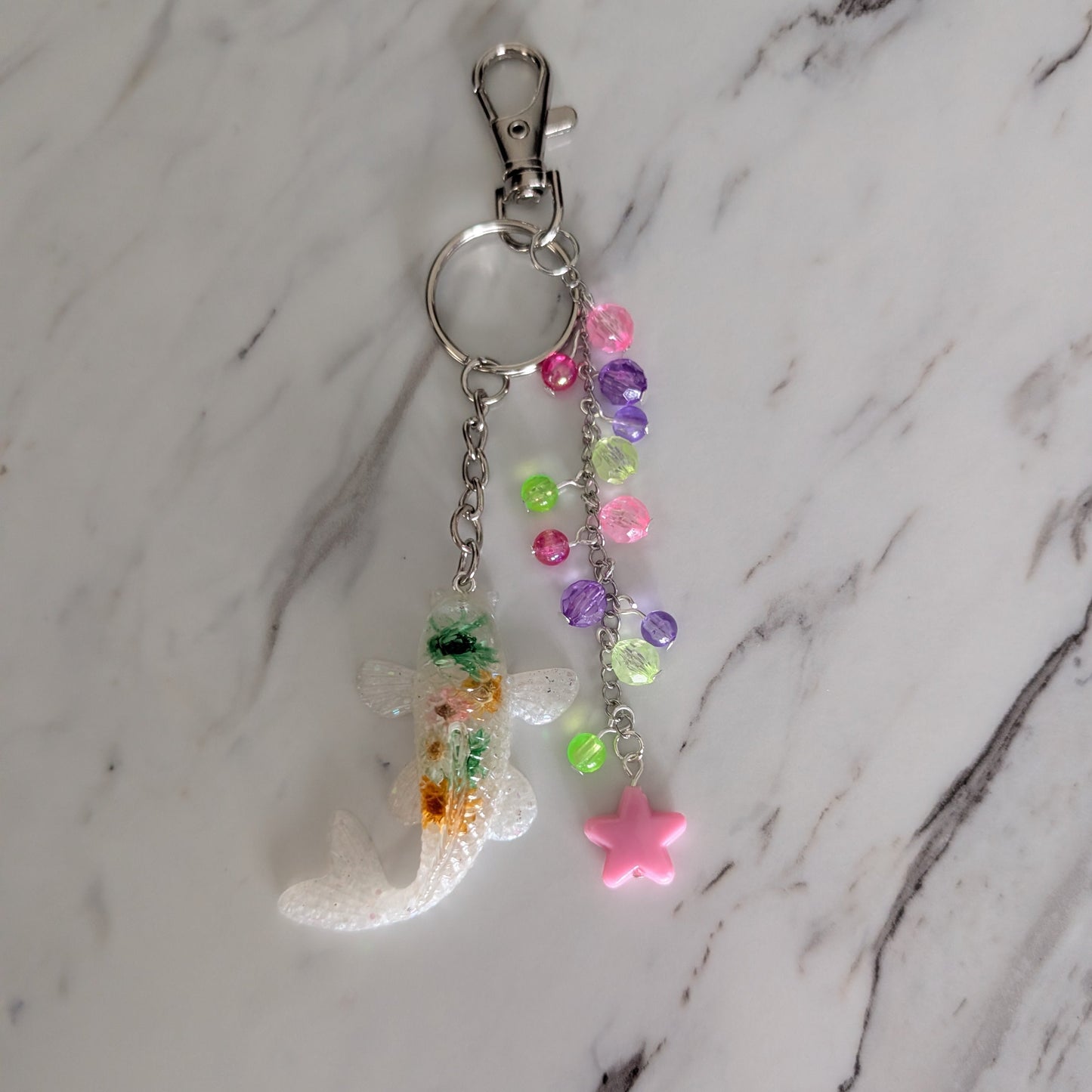 Colorful keychain with beads and a star charm on a marble background
