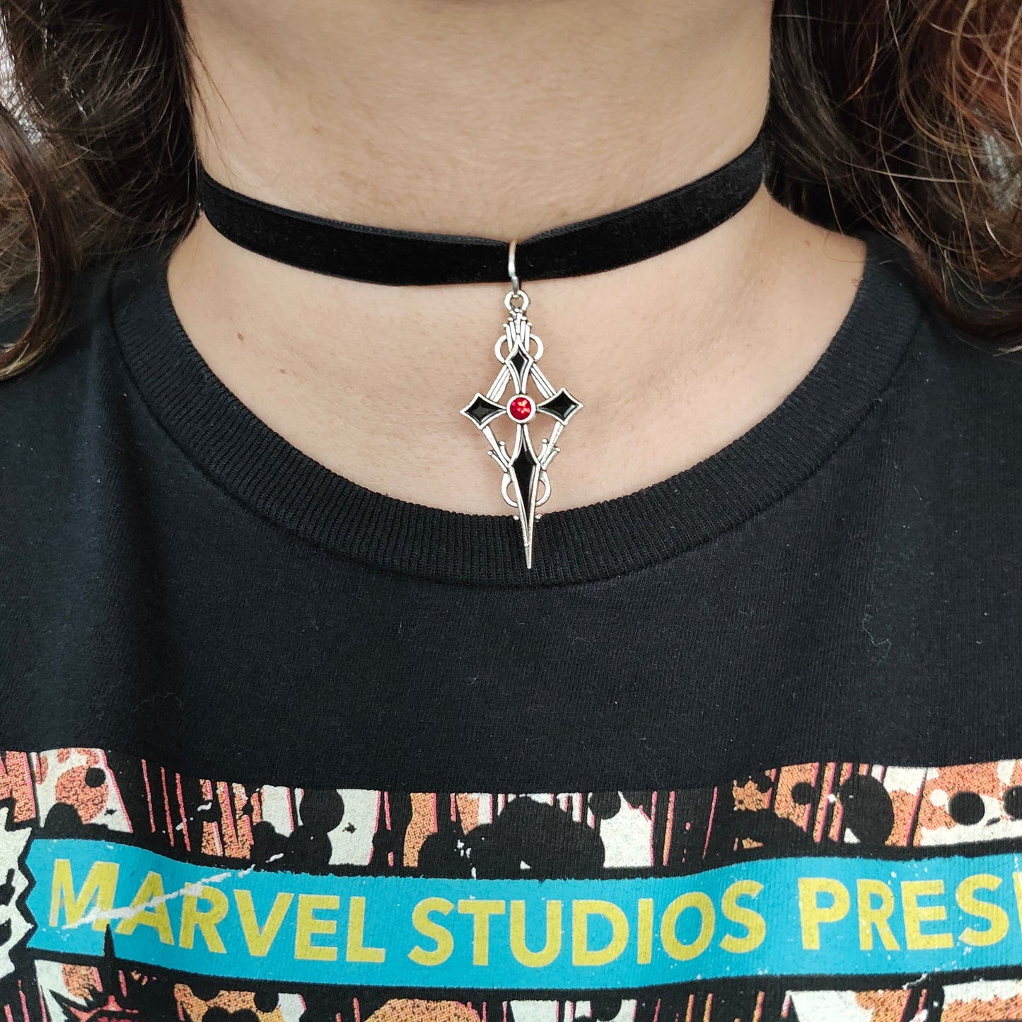 Add a touch of Gothic elegance to your outfit with our black velvet choker necklace featuring a silver cross charm. Perfect for fans of dark and edgy fashion, this necklace is sure to make a statement. Elevate your style and show off your unique personality with this eye-catching piece!