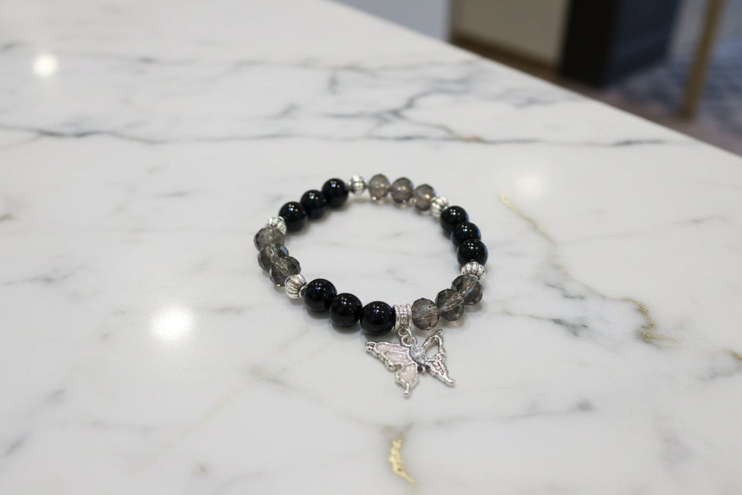Elevate your everyday style with this stunning elastic bracelet featuring lustrous 8mm black beads paired with shimmering crystal and glass accents. Delicate silver spacer beads guide your eye to the centerpiece—an elegant silver butterfly charm that symbolizes transformation and grace. Lightweight at just 0.53 oz, this versatile piece transitions seamlessly from casual to sophisticated, making it the perfect accessory for any occasion. The elastic design ensures a comfortable, adjustable fit for all wrist 