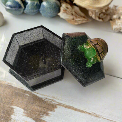 Add a playful touch to your home decor with this Knickknack! The resin hexagon trinket box features a turtle lid and is the perfect size for storing small treasures. With dimensions of 2.5 x 3 x 1 inches and weighing only 3.4 ounces, it's a quirky and lightweight addition to any room.