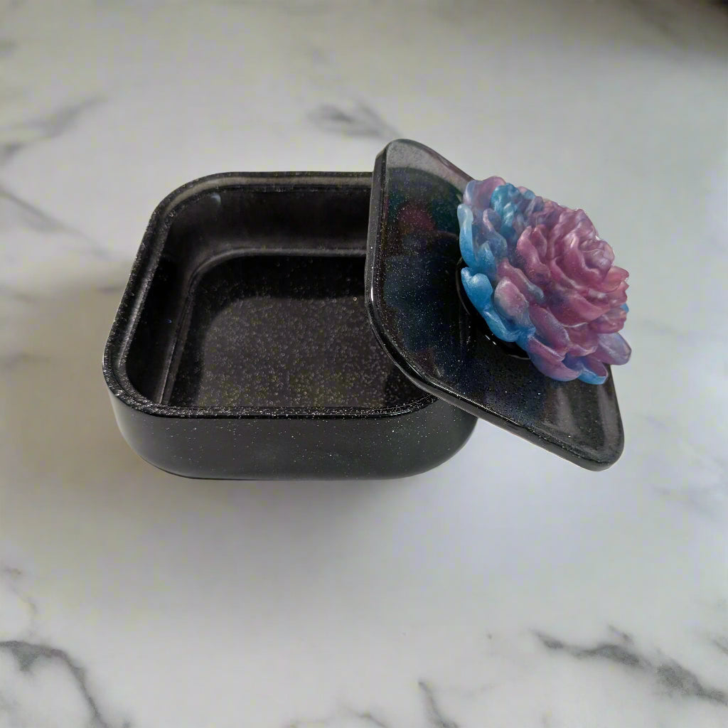 Elevate your jewelry collection with this stunning Knickknack jewelry box. Featuring a flower lid and made of durable resin, this box measures 5 x 5 inches and has a depth of 1.5 inches, making it perfect for large pieces. Weighing only 14 oz, it's also lightweight and easy to transport. Transform your dressing table and protect your precious pieces with this beautiful box.