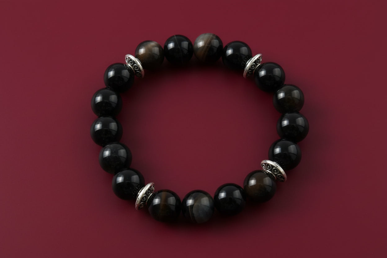 Experience the power of natural gemstones with our Black Stripe Agate Bracelet. The 6mm beads are expertly crafted for a comfortable elastic fit. The striking black stripes are complemented by silver spacer beads, adding a touch of elegance to this unique accessory. Feel confident and stylish with every wear!