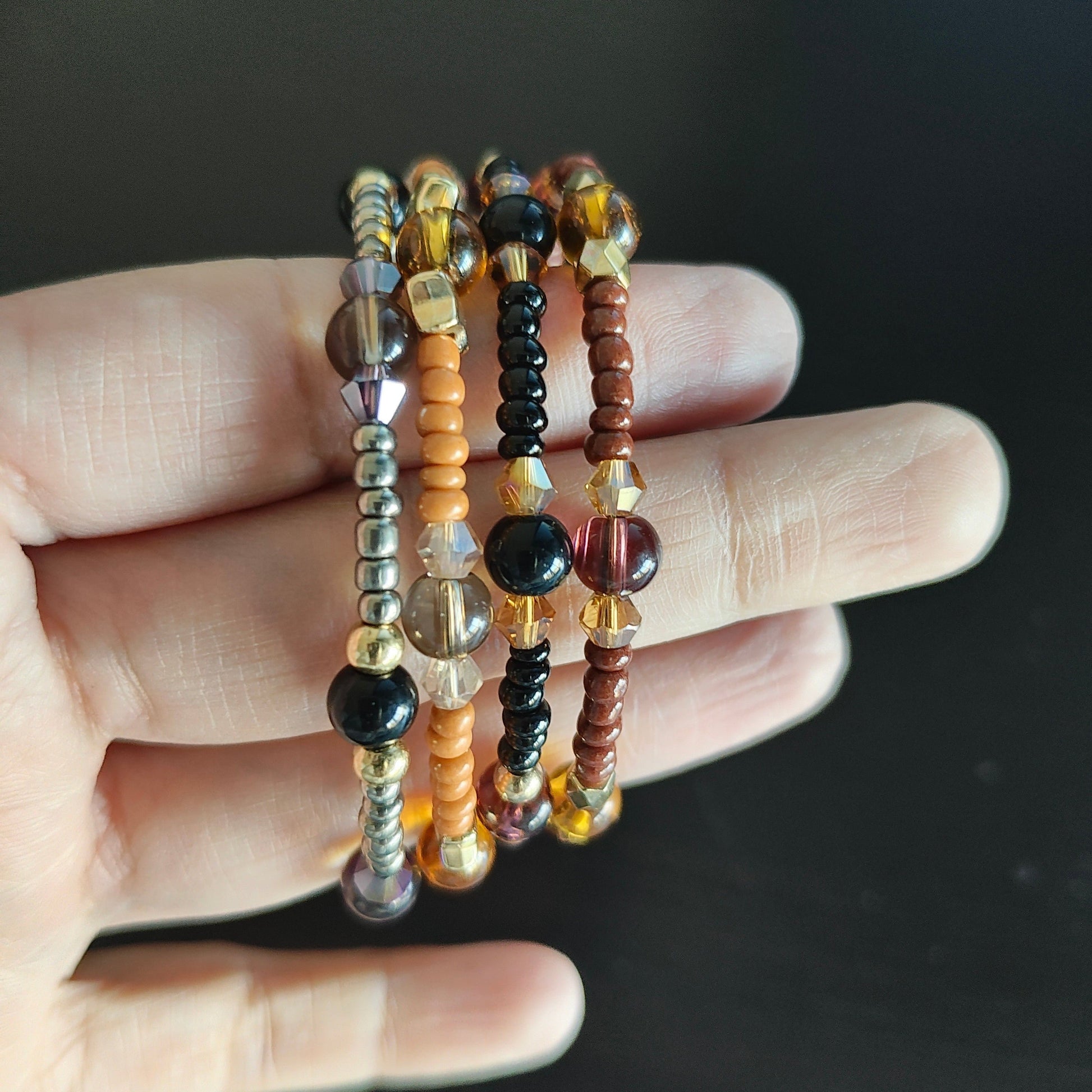 Experience the ultimate versatility and style with our 4 coil memory wire bracelet! Made with 6mm black and tan beads, accented by black, tan, and silver seed beads, and finished with eye-catching gold spacer beads. Elevate any outfit with this unique and effortless accessory.