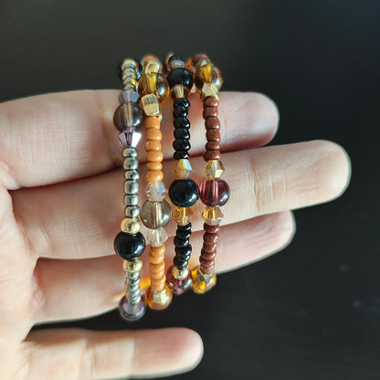 Experience the ultimate versatility and style with our 4 coil memory wire bracelet! Made with 6mm black and tan beads, accented by black, tan, and silver seed beads, and finished with eye-catching gold spacer beads. Elevate any outfit with this unique and effortless accessory.