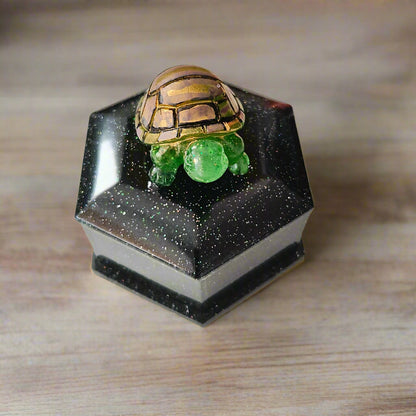 Add a playful touch to your home decor with this Knickknack! The resin hexagon trinket box features a turtle lid and is the perfect size for storing small treasures. With dimensions of 2.5 x 3 x 1 inches and weighing only 3.4 ounces, it's a quirky and lightweight addition to any room.