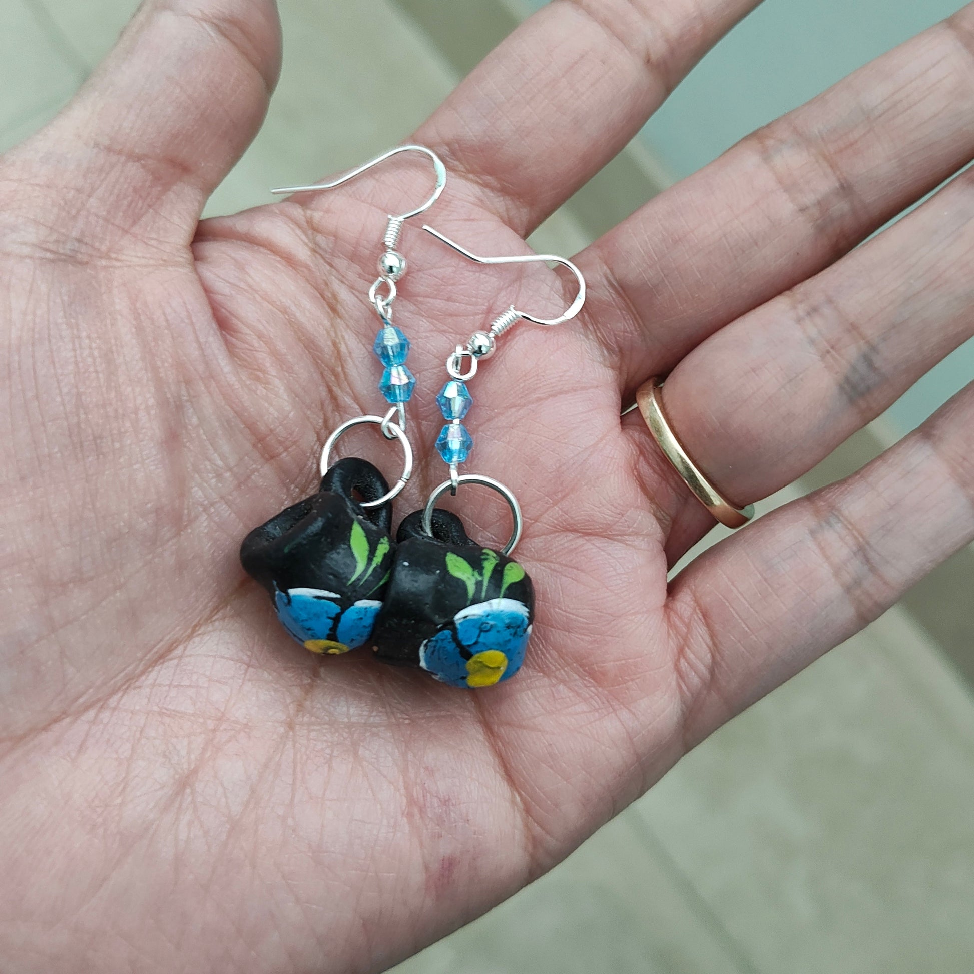These quirky earrings feature a ceramic Mexican mug with colorful beads hanging from a silver hook. With a length of approximately 2 inches and a weight of only 0.14 oz, they are lightweight and comfortable to wear. Perfect for adding a unique touch to any outfit!