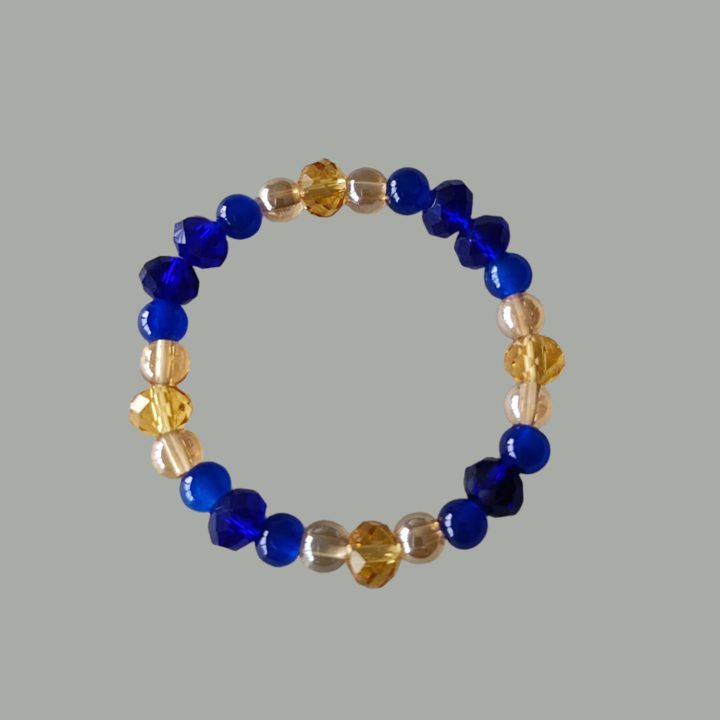 Add a touch of elegance to any outfit with our Bracelet - Elastic 6mm & 8 mm blue & gold glass beads. The elastic design ensures a comfortable fit for all wrist sizes. At a weight of just 0.38 oz, it is lightweight and easy to wear all day long. Elevate your style with this stunning bracelet.

Bracelet - Elastic 6mm & 8 mm blue & gold glass beads