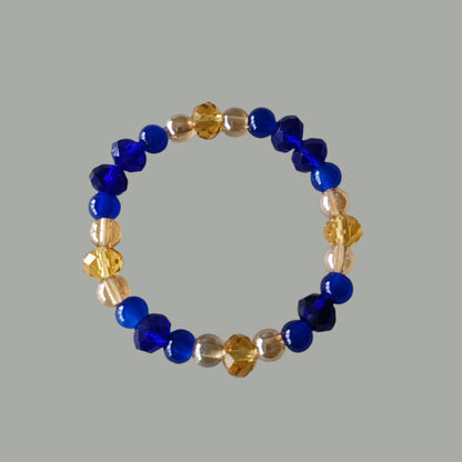 Add a touch of elegance to any outfit with our Bracelet - Elastic 6mm & 8 mm blue & gold glass beads. The elastic design ensures a comfortable fit for all wrist sizes. At a weight of just 0.38 oz, it is lightweight and easy to wear all day long. Elevate your style with this stunning bracelet.

Bracelet - Elastic 6mm & 8 mm blue & gold glass beads