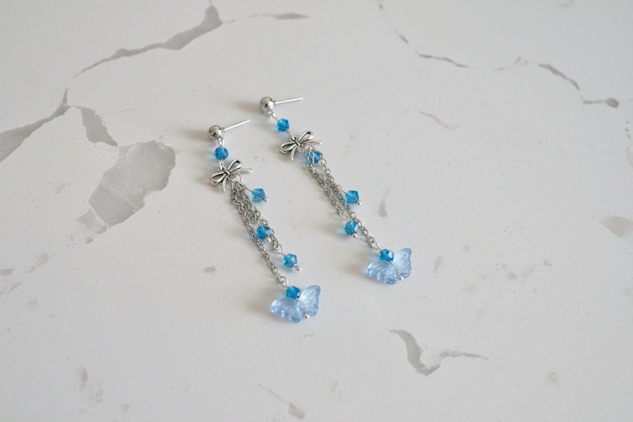 Elevate your everyday style with these enchanting butterfly earrings, featuring delicate silver chains, a charming bow accent, and sparkling crystal beads suspended from classic silver ball post studs. At approximately 3 inches in length, they offer the perfect balance of presence and wearability, making them ideal for both casual outings and special occasions. Weighing just 0.18 oz, these lightweight beauties won't weigh you down, allowing you to wear them comfortably all day long. The intricate design com