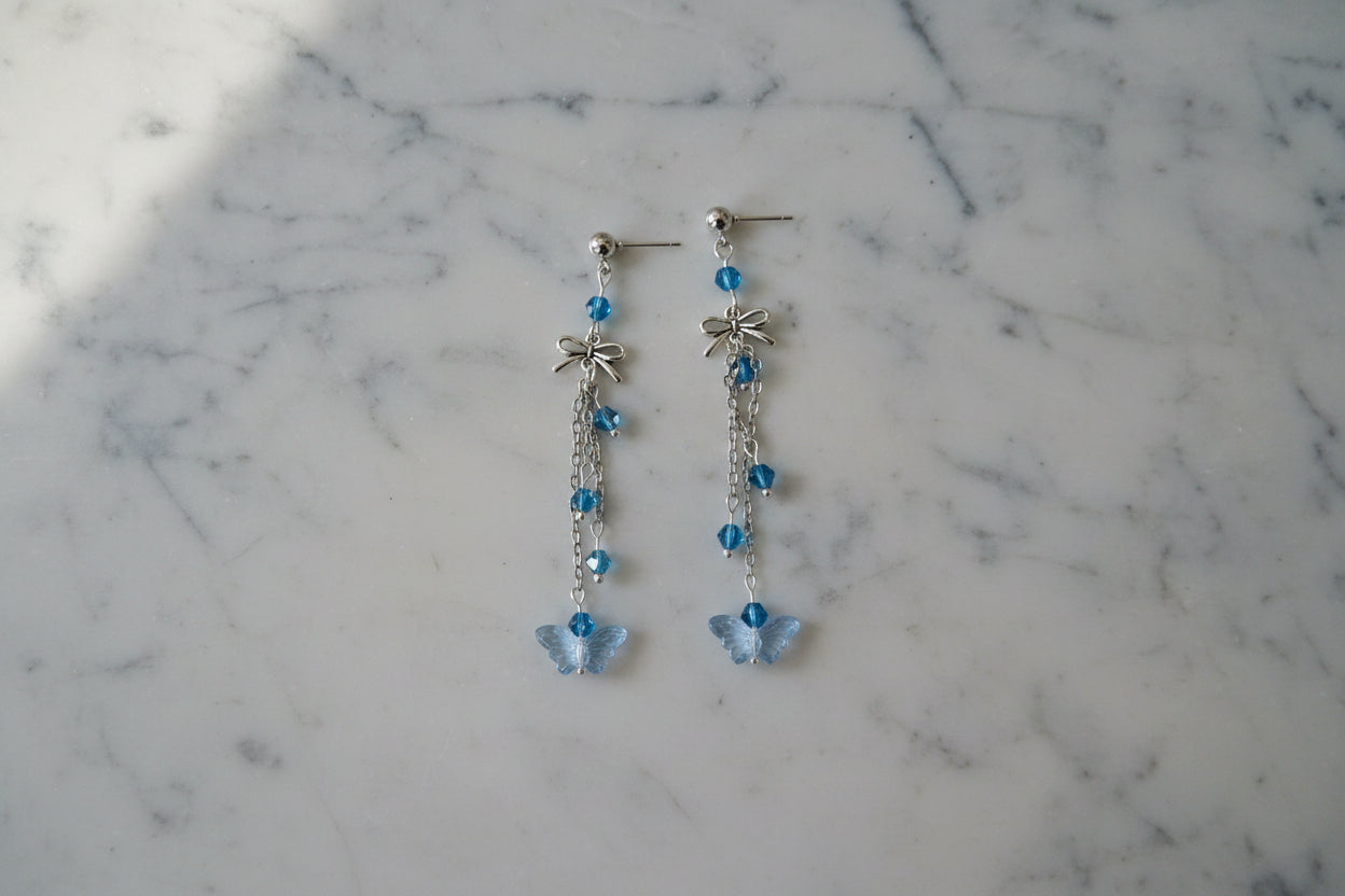 Elevate your everyday style with these enchanting butterfly earrings, featuring delicate silver chains, a charming bow accent, and sparkling crystal beads suspended from classic silver ball post studs. At approximately 3 inches in length, they offer the perfect balance of presence and wearability, making them ideal for both casual outings and special occasions. Weighing just 0.18 oz, these lightweight beauties won't weigh you down, allowing you to wear them comfortably all day long. The intricate design com