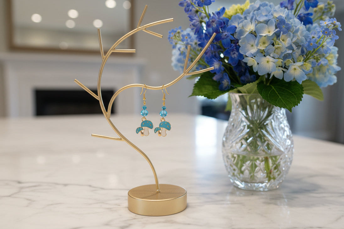 Enchanting mushroom earrings featuring delicate crystal beads nestled on lustrous gold plated hooks. Each earring measures approximately 2 inches, striking the perfect balance between statement-making and wearable elegance. At just 0.15 oz per pair, these lightweight beauties won't weigh you down, making them ideal for all-day wear. The shimmering gold plating catches the light beautifully, while the crystal accents add a touch of sparkle and sophistication. 