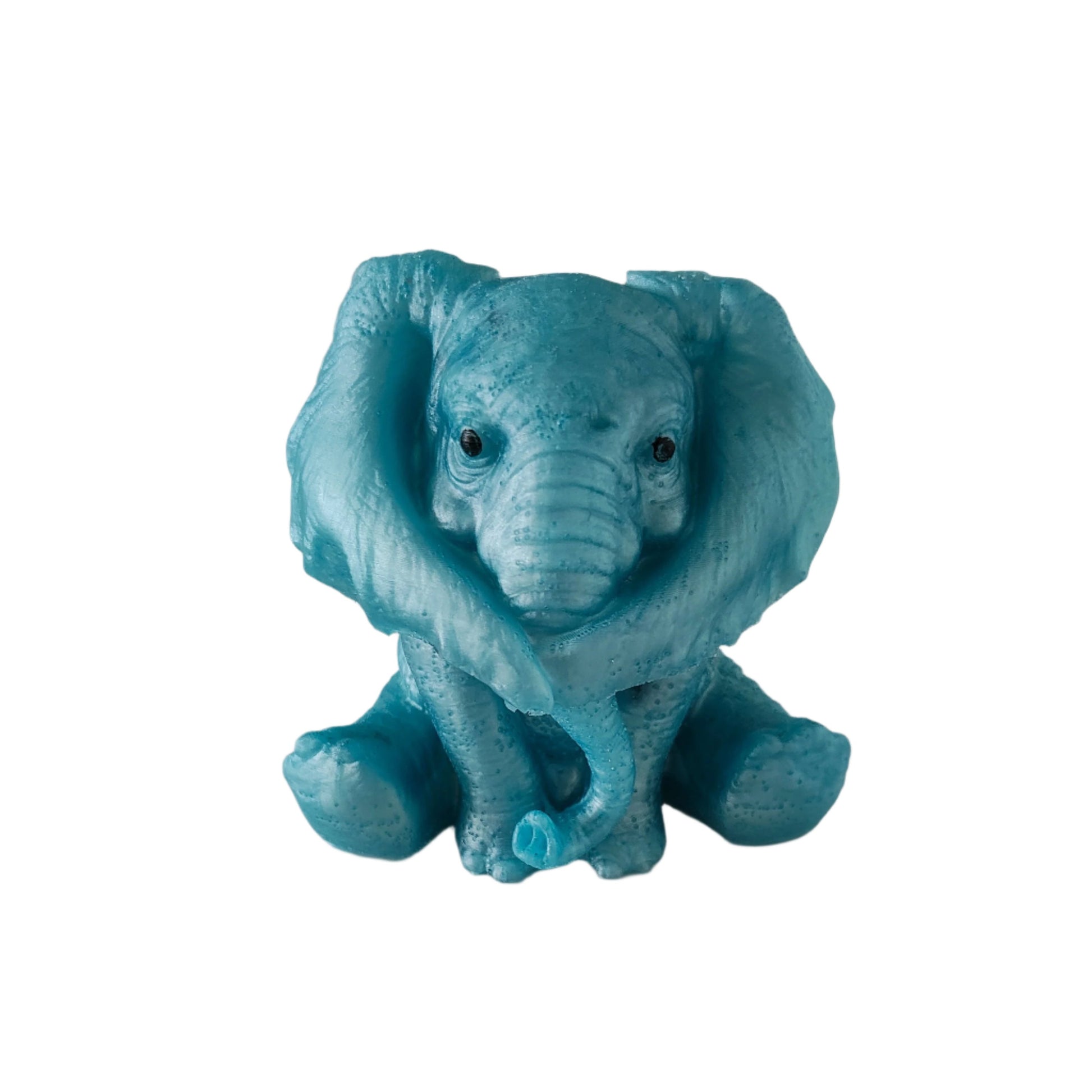 Close-up of a handcrafted blue epoxy resin elephant figurine with its large ears tucked forward, representing hear no evil.