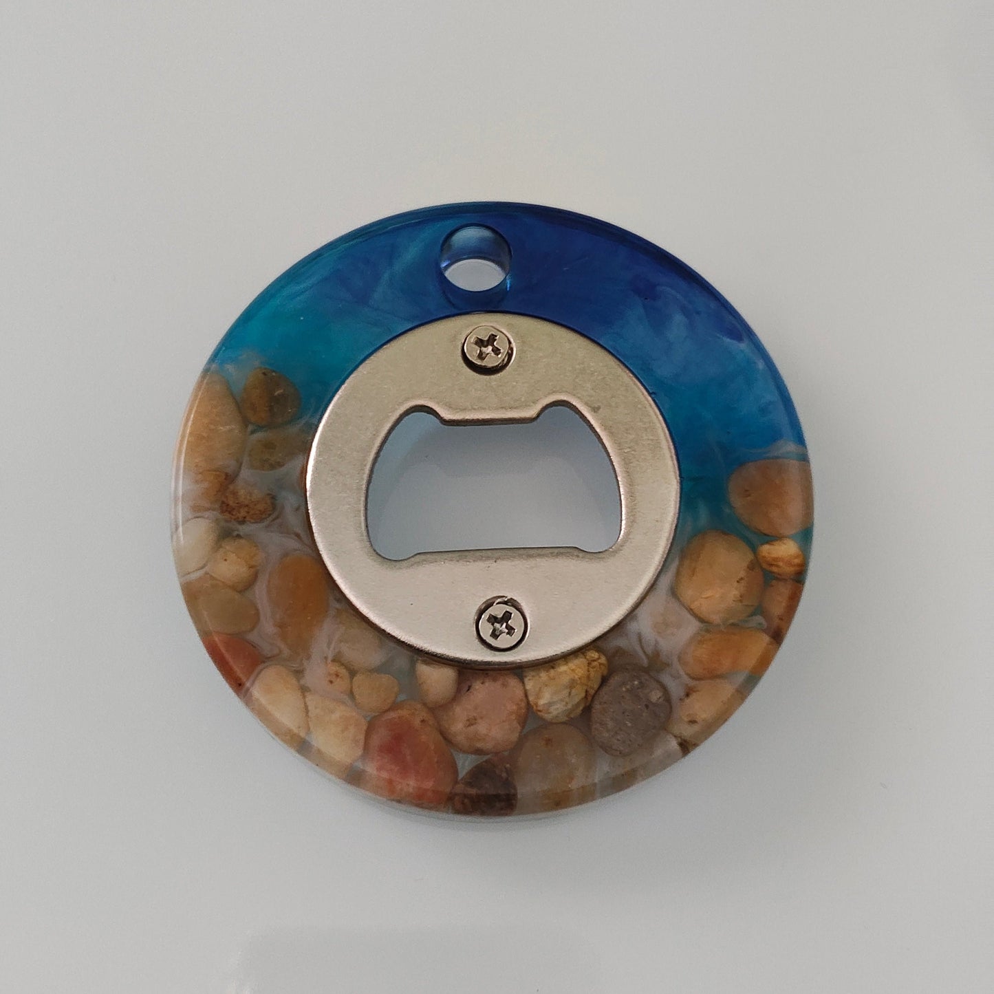 Introducing the perfect addition to your bar-ware collection - the Knickknack Round Resin Bottle Opener! Its sleek design and sturdy material make it easy to open your favorite beverages with style and ease. Say goodbye to struggling with bottle openers and hello to effortless entertaining.