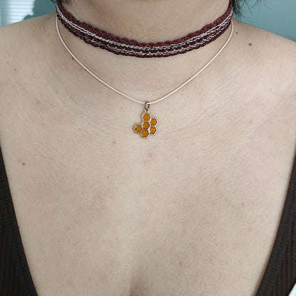 Add a touch of quirkiness to your outfit with our brown lace choker featuring a playful honey comb charm. Made with a durable polyester strand, it's both stylish and versatile for any occasion. Don't be afraid to let your personality show with this unique necklace!