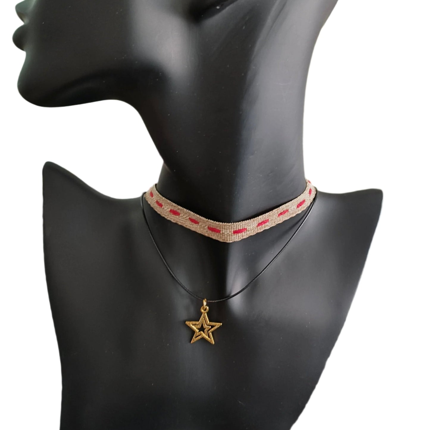 This brown/red ribbon choker necklace features a combination of polyester and gold, creating a unique and stylish look. The gold star charm adds an elegant touch. Enhance any outfit with this versatile accessory.