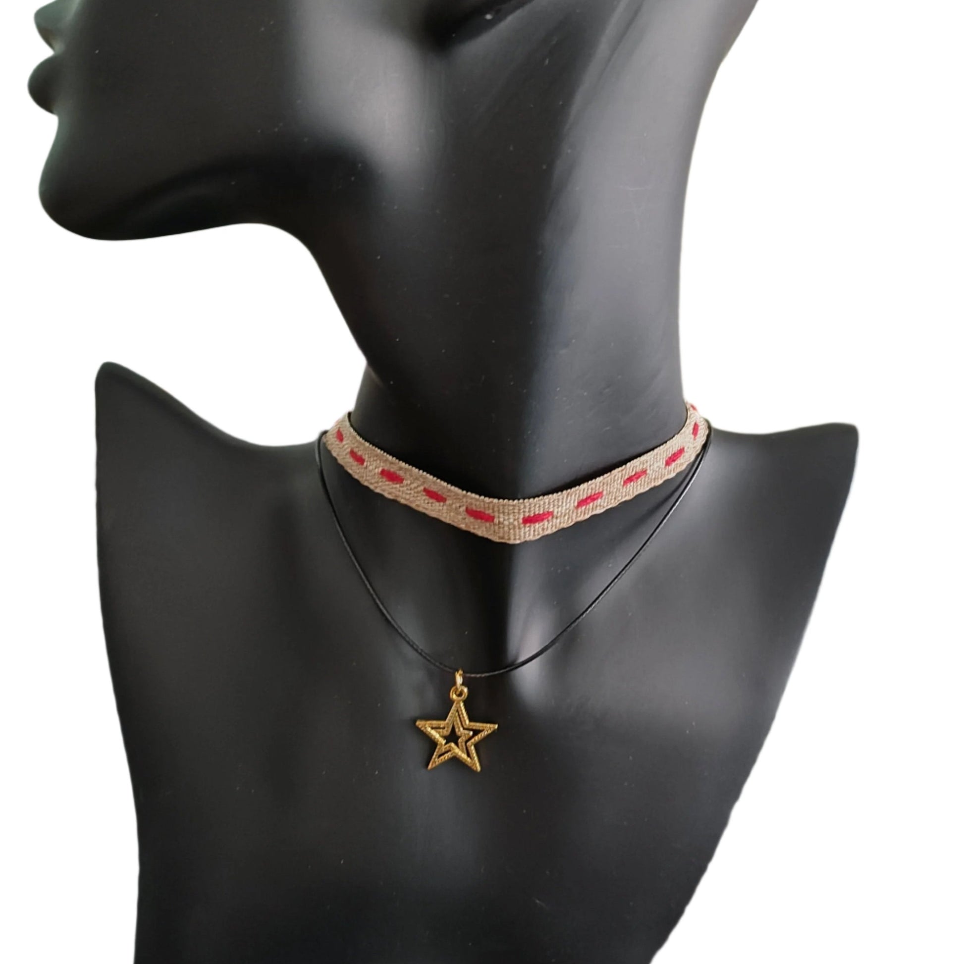 This brown/red ribbon choker necklace features a combination of polyester and gold, creating a unique and stylish look. The gold star charm adds an elegant touch. Enhance any outfit with this versatile accessory.