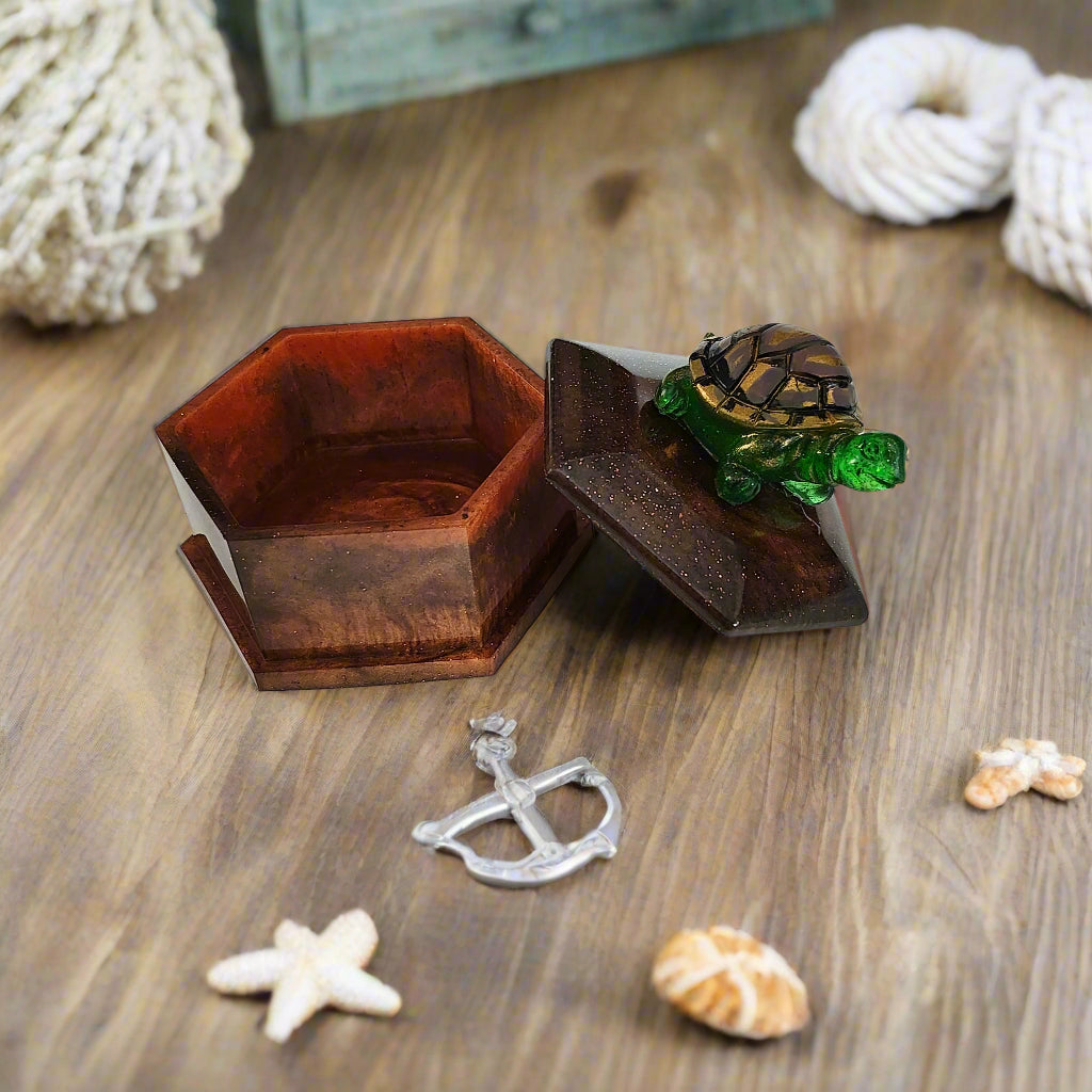 Add a playful touch to your home decor with this Knickknack! The resin hexagon trinket box features a turtle lid and is the perfect size for storing small treasures. With dimensions of 2.5 x 3 x 1 inches and weighing only 3.4 ounces, it's a quirky and lightweight addition to any room.