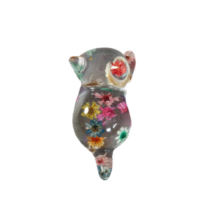 Add some purrfect charm to your home with our playful "Knickknack" resin cat trinket. This small, clear feline is adorned with delicate flowers, making it both stylish and quirky. A unique addition to any knickknack collection.
