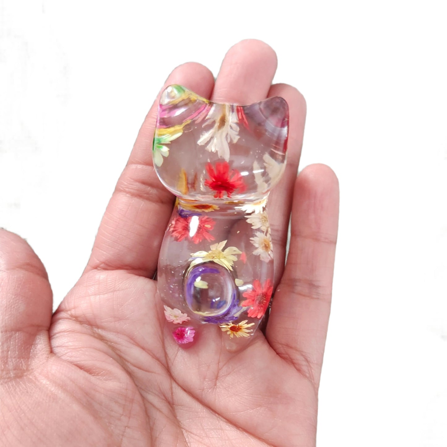 Add some purrfect charm to your home with our playful "Knickknack" resin cat trinket. This small, clear feline is adorned with delicate flowers, making it both stylish and quirky. A unique addition to any knickknack collection.