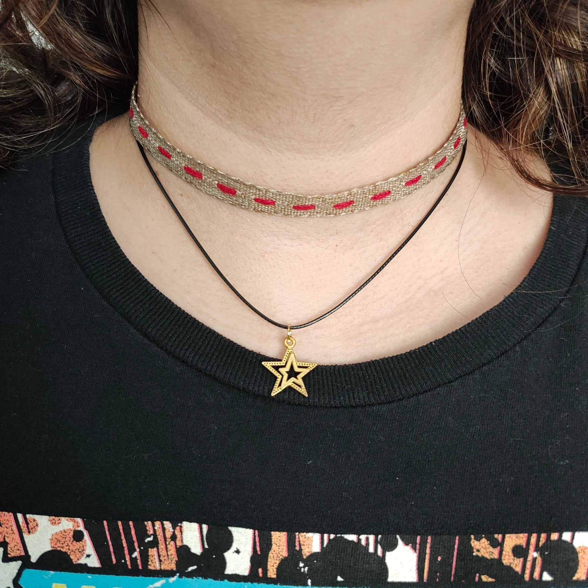 This brown/red ribbon choker necklace features a combination of polyester and gold, creating a unique and stylish look. The gold star charm adds an elegant touch. Enhance any outfit with this versatile accessory.