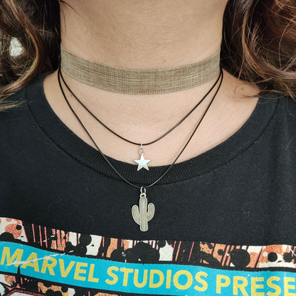 Elevate your style with this trendy and unique choker necklace. The brown ribbon adds a touch of warmth while the silver star and cactus charms add a playful and chic touch. Made with two polyester strands for durability and comfort. A must-have addition to your jewelry collection.